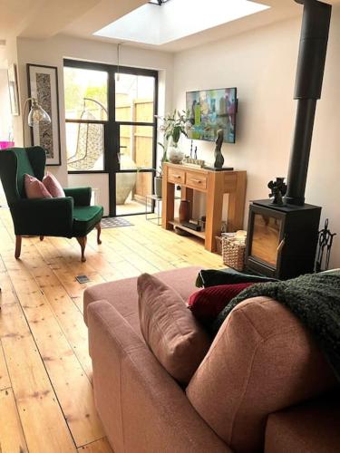a living room with a couch and a wood stove at Our beautifully renovated home in Chichester