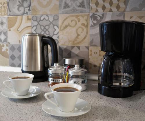 two cups of coffee sitting on a kitchen counter at Meteora Mosaico House in Kastrákion