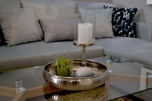 a candle on a table in front of a couch at Meteora Mosaico House in Kastrákion