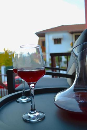 two glasses of red wine sitting on a table at Meteora Mosaico House in Kastrákion