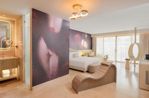 ein Hotelzimmer mit einem Bett und einem Badezimmer in der Unterkunft Desire Riviera Maya Resort All Inclusive - Couples Only in Puerto Morelos