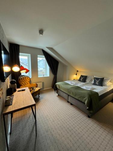 sypialnia z dużym łóżkiem i stołem w obiekcie Arctic Hotel Nordkapp w mieście Honningsvåg