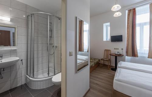 ein Bad mit einer Dusche, einem WC und einem Waschbecken in der Unterkunft Hotel Terminus in Wien