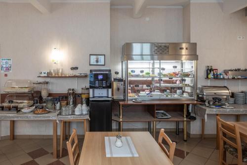 uma grande cozinha com uma mesa e um frigorífico em Hotel Terminus em Viena