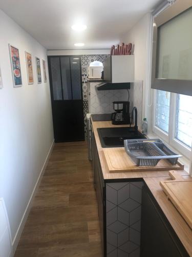 une cuisine avec un évier et un plan de travail dans l'établissement Meublés déco Fab - Plancha, à Luxeuil-les-Bains