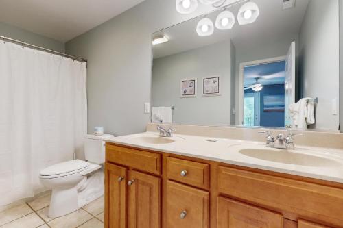 bagno con lavandino, servizi igienici e specchio di Bear Trap Dunes - 17 Village Green a Ocean View