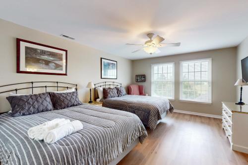 Un dormitorio con dos camas y un ventilador de techo. en Bear Trap Dunes - 17 Village Green, en Ocean View