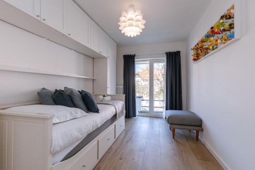 a bedroom with a large bed and a chandelier at Pins Dorés - A Luxurious and beautifully decorated villa with terrace and parking near the beach in Knokke-Heist