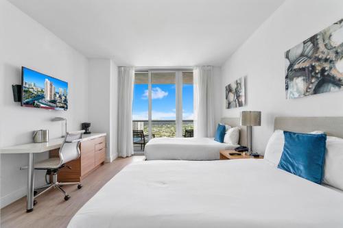Habitación de hotel con 2 camas, escritorio y ventana en Panoramic views Studio on the 27th floor Beachwalk en Hollywood