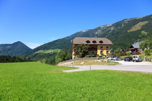 a building on the side of a road with a green field at Stiegenwirt in Palfau