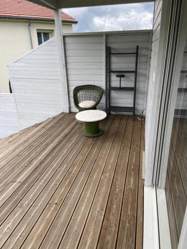 a porch with a bench on a wooden deck at Bungalow dans le jardin in Saint-Étienne