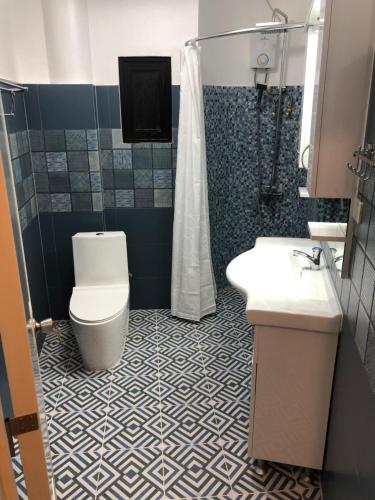 ein Bad mit einem WC, einem Waschbecken und einer Dusche in der Unterkunft Cuestas Beach Resort and Restaurant in Badian