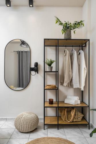 a mirror on a wall next to a shelf with clothes at Rivulet Apartments in Laganas