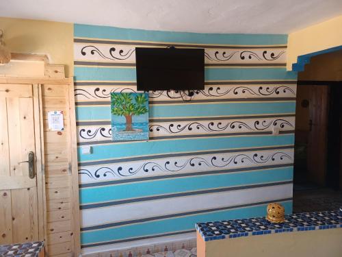 een kamer met een muur met blauwe en witte strepen bij Superbe appartement , grande terrasse vue mer et montagne Taghazout in Taghazout