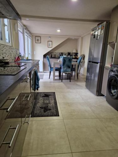 Il comprend une cuisine et une salle à manger avec une table et un réfrigérateur. dans l'établissement Jasmin, à Vitry-sur-Seine