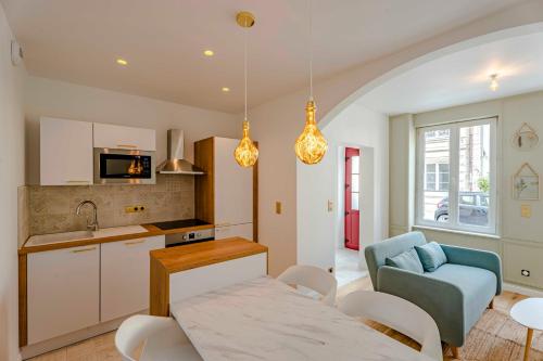 une cuisine et un salon avec une table et des chaises dans l'établissement Petit Appartement Cosy proche Centre historique, à Caen