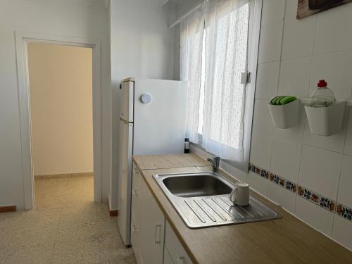 a kitchen with a sink and a refrigerator at Encantadora casa en el corazón de Estepona in Estepona