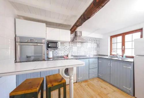 a kitchen with blue cabinets and white appliances at La Casina de la Peña in Luarca
