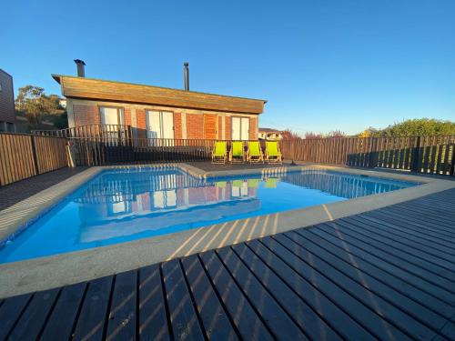 une piscine avec une terrasse en bois et une maison dans l'établissement Casa en Algarrobo, parcela en sector Mirasol, à Algarrobo