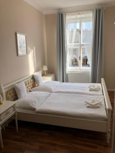 - une chambre avec un grand lit et une fenêtre dans l'établissement Penzion Florián Telč, à Telč