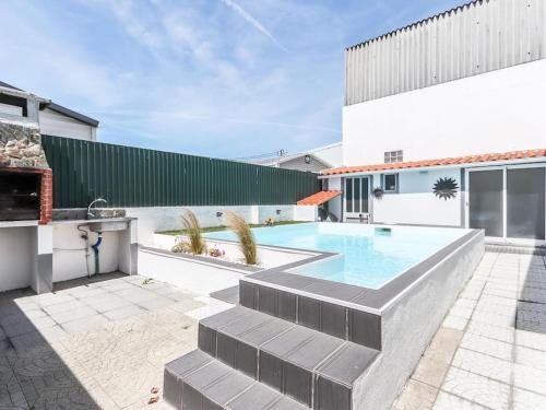a backyard with a swimming pool and a building at Vita Portucale ! Charneca Caparica Pool in Charneca