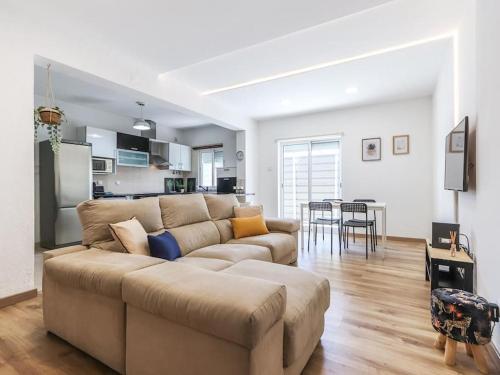 a living room with a couch and a kitchen at Vita Portucale ! Charneca Caparica Pool in Charneca