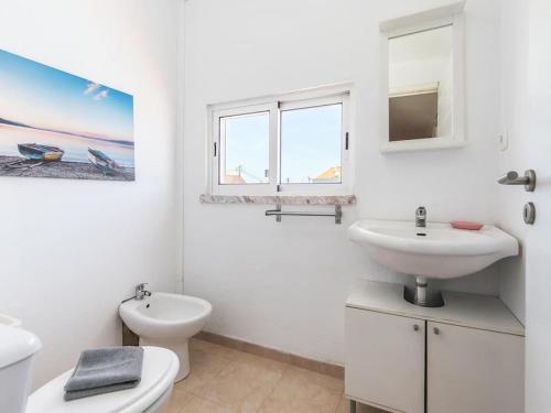 ein weißes Badezimmer mit Waschbecken und Toilette in der Unterkunft Vita Portucale ! Charneca Caparica Pool in Charneca