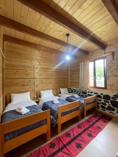 1 dormitorio con 2 camas en una cabaña de madera en Royal Land, en Theth
