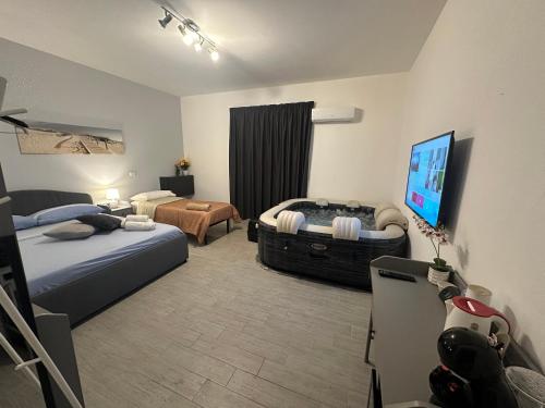 um quarto de hotel com duas camas e uma televisão de ecrã plano em Affittacamere Gess em Montalto Uffugo