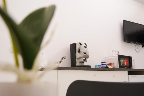 a room with a desk with a tv and a coffee maker at B&B Vesuvius Central in Torre del Greco