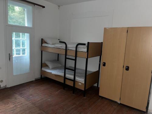 a room with two bunk beds next to a door at Waldschlösschen Ricklingen in Hannover