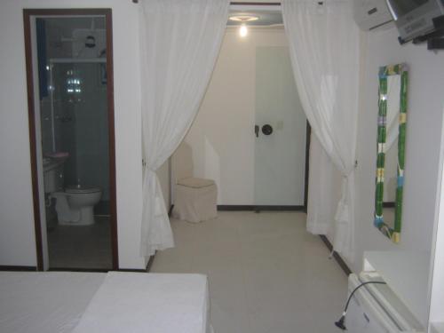 a bathroom with a bed and a shower and a toilet at Guest House Green Garden in Búzios