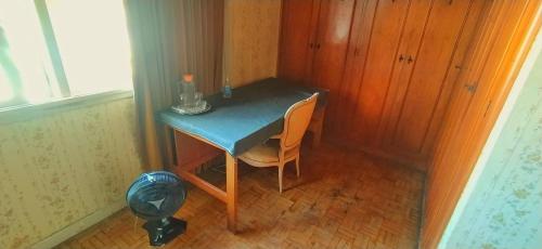 mały niebieski stół z krzesłem w pokoju w obiekcie Suíte Cama Casal Queen Banheiro só seu CGH w São Paulo