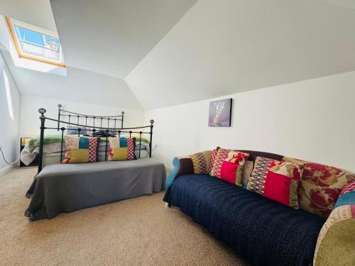 a living room with a bed and a couch at Stylish modern Mews house in central St Leonards in Hastings