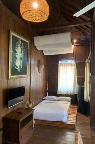 a bedroom with a bed and a tv in it at Negla Beach Villa in Godog