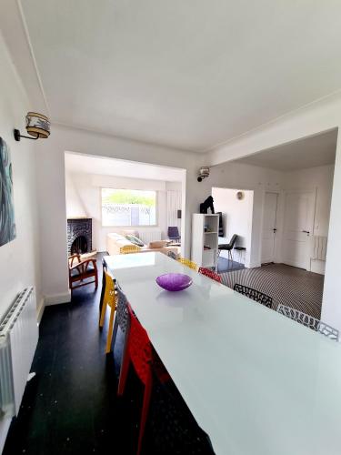 une cuisine et un salon avec un comptoir blanc dans l'établissement Agréable Villa à mi-chemin de Paris & Disneyland & Stade de France, à Gagny