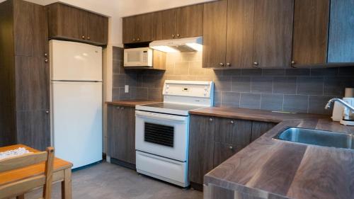a kitchen with a white stove and a refrigerator at MontREAL HOMES - Affordable Rooms, Smart TV, Shared Kitchen in Montréal