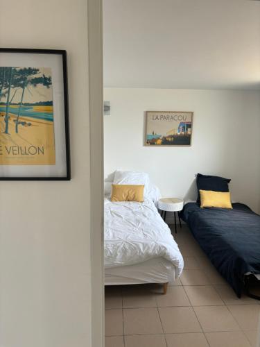 - une chambre avec 2 lits et une table dans l'établissement villa plage les Sables d’Olonne, à La Chaume