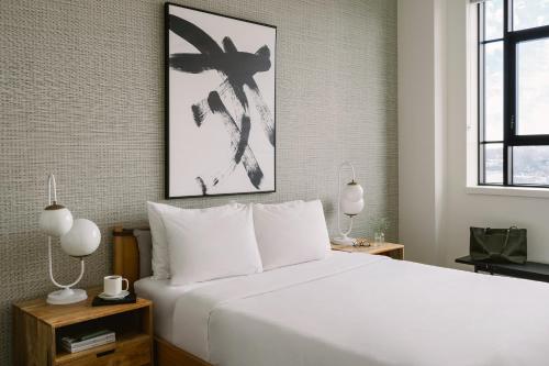 een slaapkamer met een groot wit bed met 2 lampen bij Sonder Le Guerin in Montreal