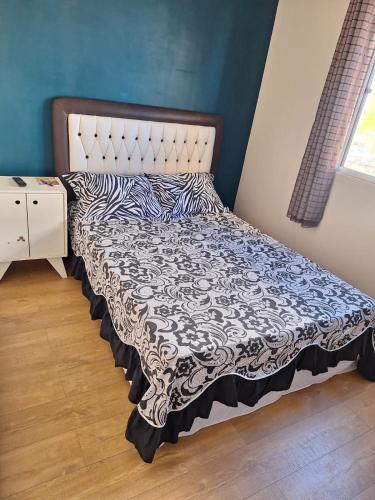 uma cama com um edredão preto e branco num quarto em APTO POUSADA MANU LAGES tordesilhas em Lages