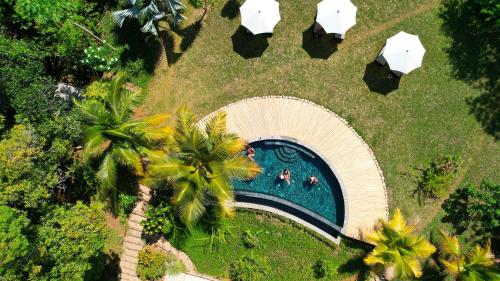 una vista aérea de una piscina en un parque con palmeras en Miavaka Lodge, en Ambatobe
