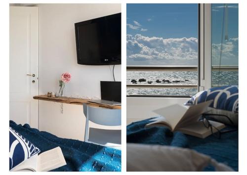 a living room with a television and a table with a book at fronte mare spiaggia - marine 59 in Diano Marina