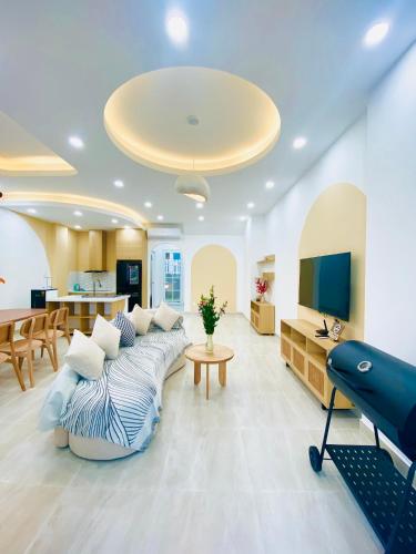a living room with a couch and a tv at Holiday Villa Novaworld Phan Thiet in Phan Thiet