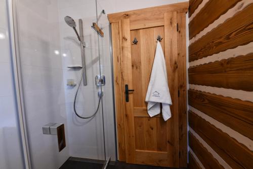 a bathroom with a shower and a wooden door at Tri borovice in Liptovský Mikuláš