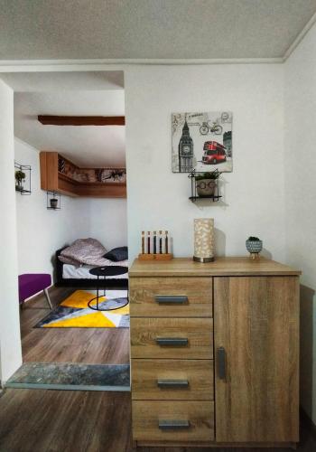 a room with a wooden dresser and a bedroom at Apartman Monroe in Sarajevo