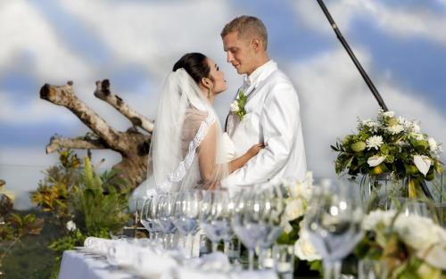 a bride and groom kissing at their wedding reception at Sovereign Bali Hotel in Kuta