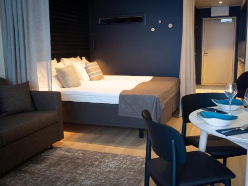 a hotel room with a bed and a table and chairs at Nallikari Seaside Aalto Apartments in Oulu