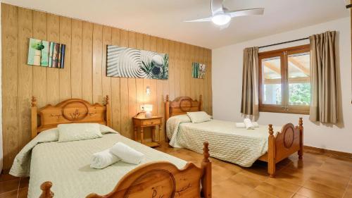 a bedroom with two beds and a window at Villa Josefina in Pollença