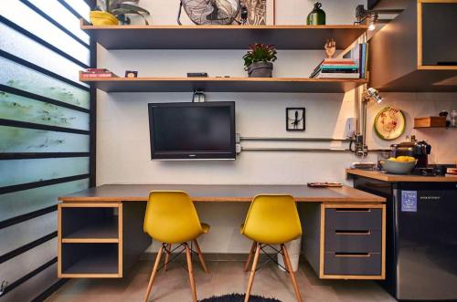 a desk with two yellow chairs in a room at Vila Pitanga Hosting in Sao Paulo