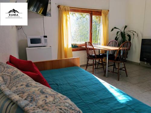 a bedroom with a bed and a table and chairs at Cabaña con Vista al Lago en Barrio Melipal - Bariloche in San Carlos de Bariloche